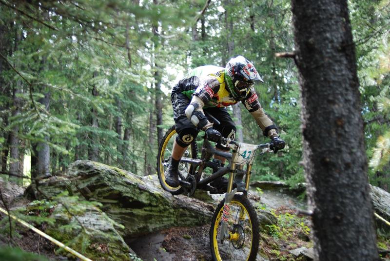 Downhill-Rennen über Felsen im Wald