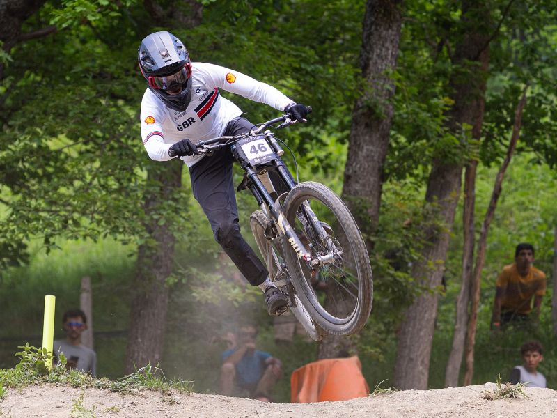 Downhill-Fahrer springt im Wald beim Weltcup in Loudenvielle